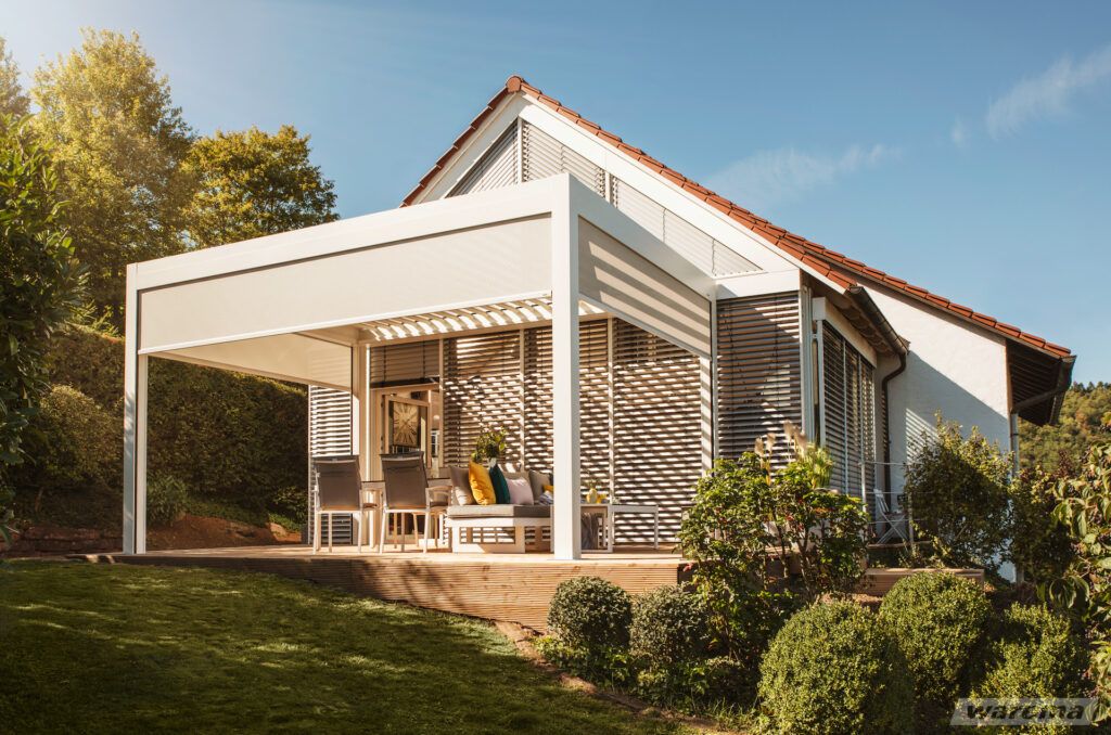 Lamellendach Cubus Lounge auf einer Terrasse an einem Einfamilienhaus mit Garten